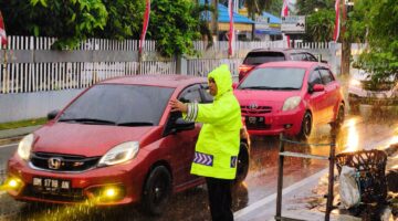 Tak Kenal Cuaca, Polantas Pekanbaru Atur Lalin di Tengah Hujan Deras